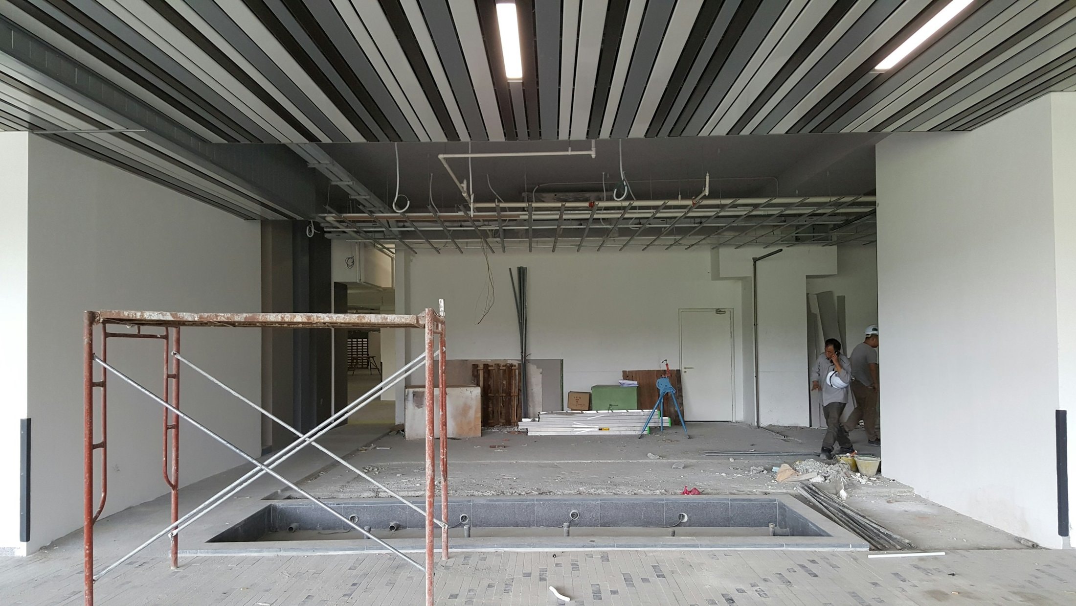 Office floor stripped back for renovation, with scaffolding under the open ceiling