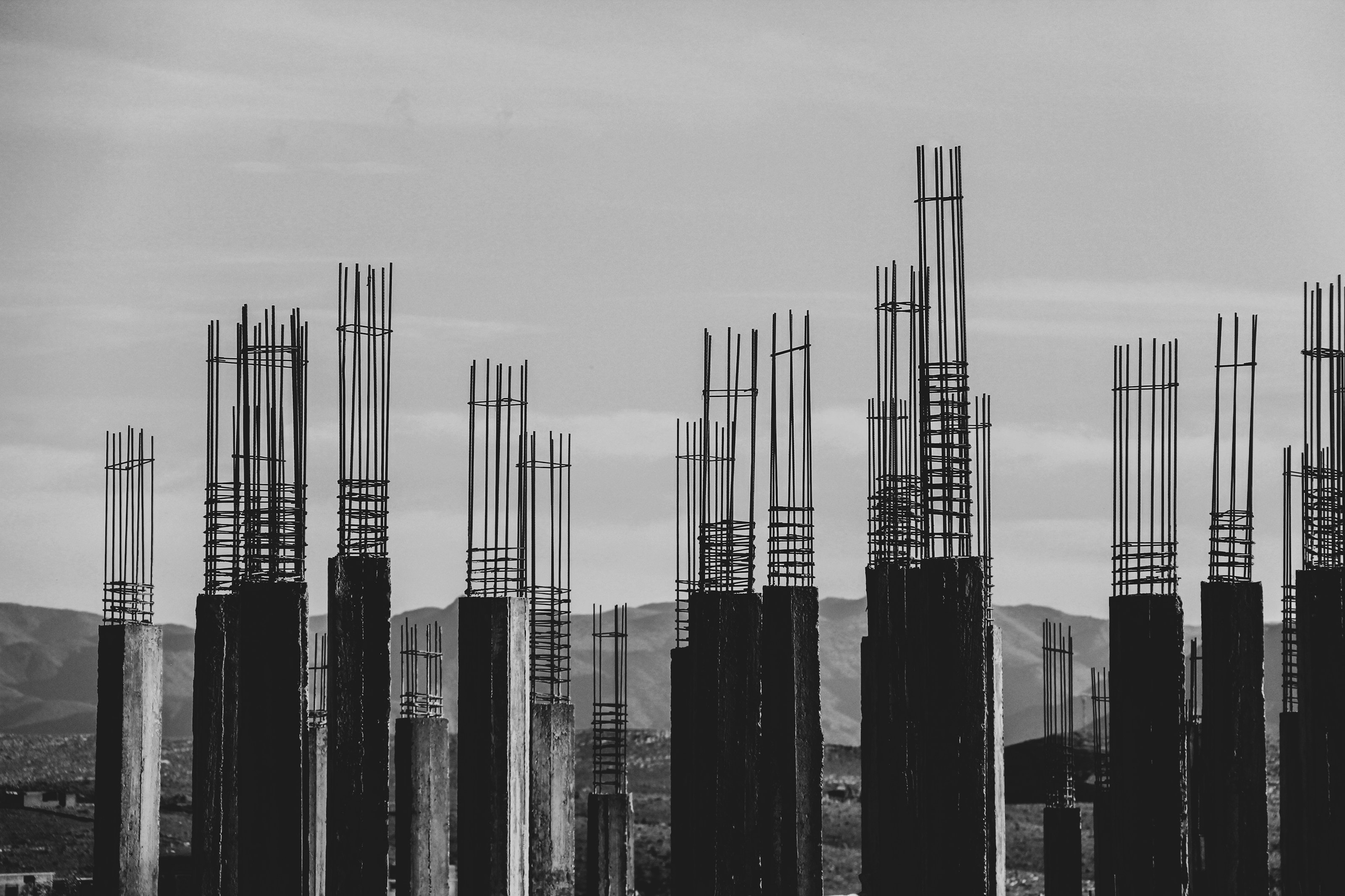 Concrete columns with reinforcement bars rising against the sky